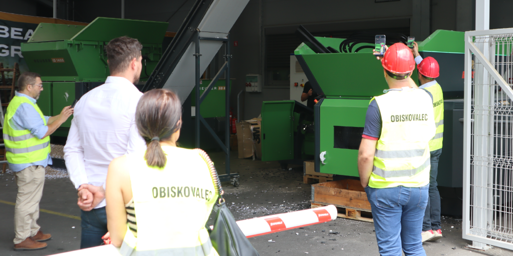 Drobilnik Robust SD 1300 med prikazom delovanja v živo, medtem ko obiskovalci dogodka Robust Distributor Event 2026 opazujejo in snemajo demonstracijo s pametnimi telefoni.