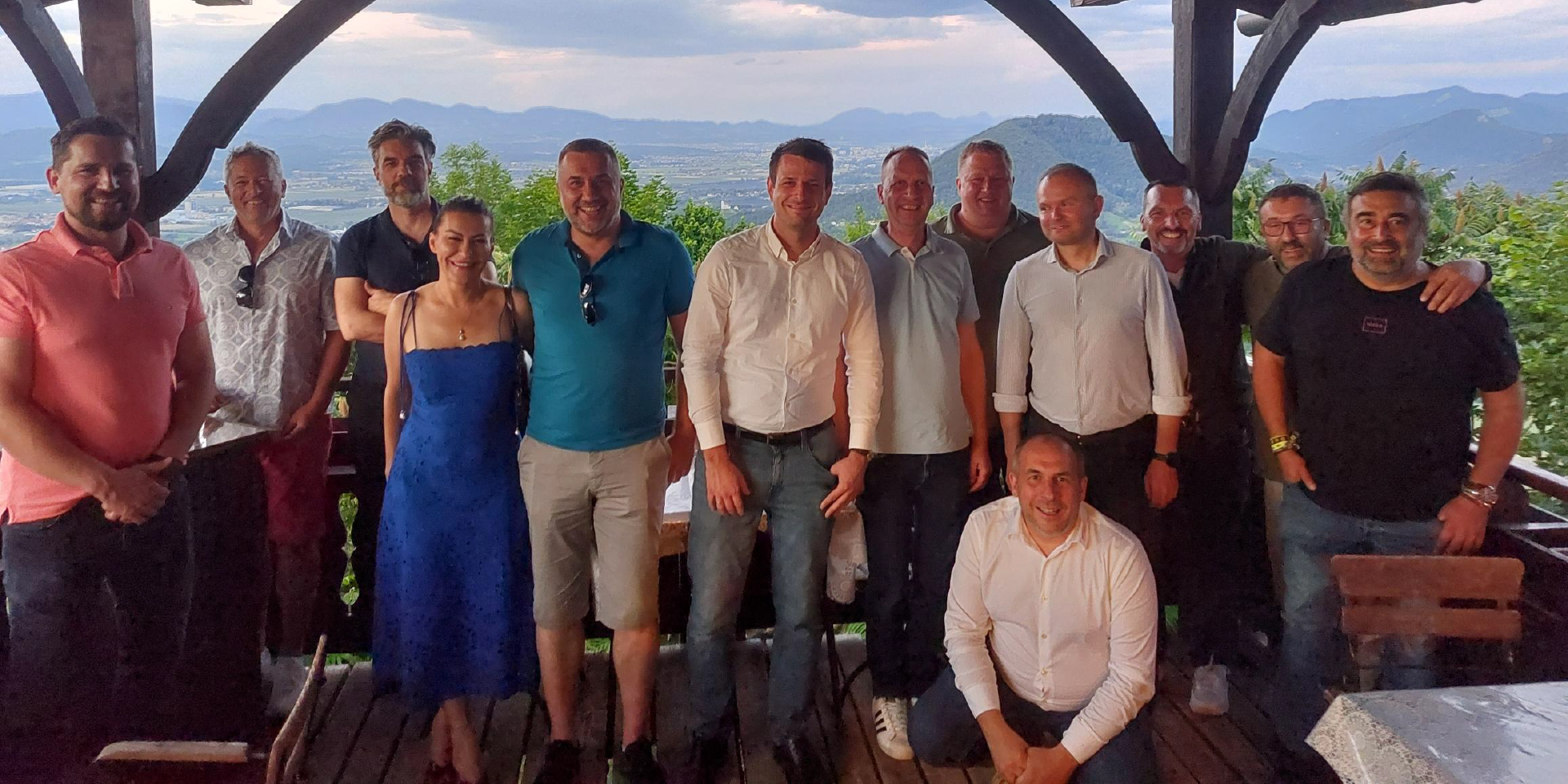 Nasmejana skupinska fotografija mednarodnih poslovnih partnerjev in ekipe Robust na družabni večerji med dogodkom Robust Distributor Event 2026.